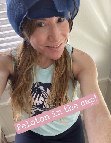 Jennifer wears a cold cap on a Peloton bike