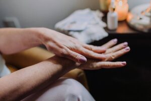 Woman massaging her hands while experiencing tingling and numbness from chemotherapy-induced peripheral neuropathy